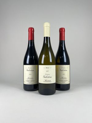 trois bouteilles de vin posées sur une table blanche