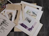 a pile of old postcards sitting on a wooden floor