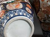 pair of asian vases sitting side by side on a gray surface