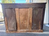 a wooden cabinet that is sitting outside on the street