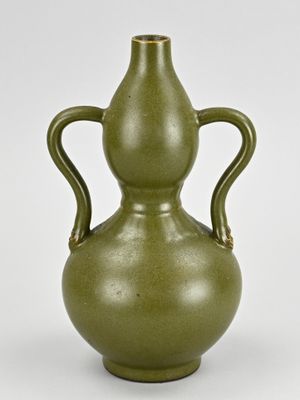 un vase vert à deux anses sur fond blanc