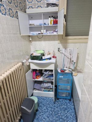une petite salle de bains avec des toilettes, un lavabo et un meuble de rangement