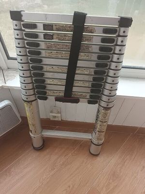 a stack of ladders sitting on the floor by a window