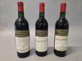 three bottles of red wine sitting next to each other on a table