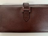 portefeuille en cuir marron avec un fermoir métallique sur le devant