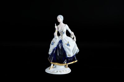 figurine représentant une femme en robe bleue tenant un panier de fleurs
