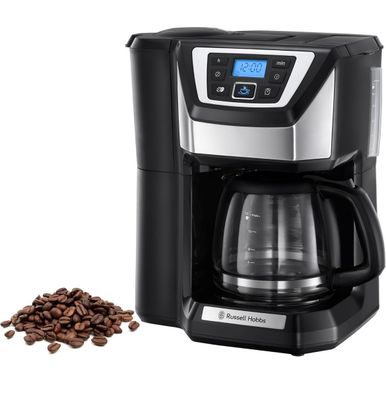 une cafetière noire et argentée à côté d'un tas de grains de café