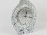a small crystal clock sitting on a white surface