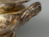 a silver bowl with a lid on a white table