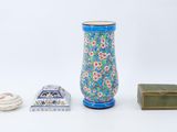 a blue vase and a small box on a white surface