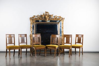 six chairs in front of a mirror in a room