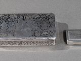 deux boîtes en argent posées l'une à côté de l'autre sur une table