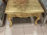 une table basse dorée et deux chaises dans une pièce