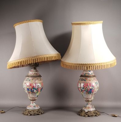 une paire de lampes posées sur une table, avec un abat-jour blanc et une bordure dorée