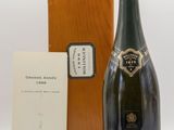 the bottle of champagne is next to a wooden box and a card