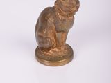 une petite statue représentant un chat assis sur une table