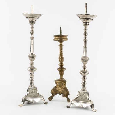 a pair of silver candlesticks on stands on a white background