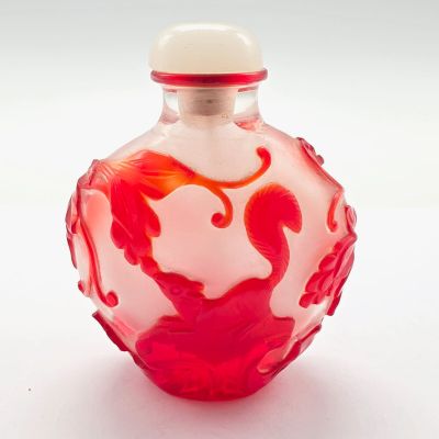 une bouteille en verre ornée d'un motif rouge et blanc