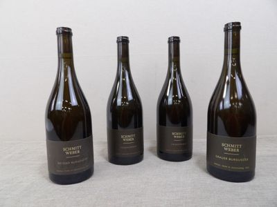 quatre bouteilles de vin sont alignées sur une table