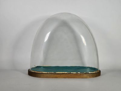 une image représentant un dôme en verre reposant sur un socle en bois, posé sur une surface blanche