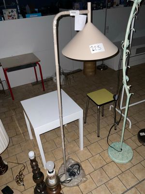 une lampe posée par terre à côté d'une table
