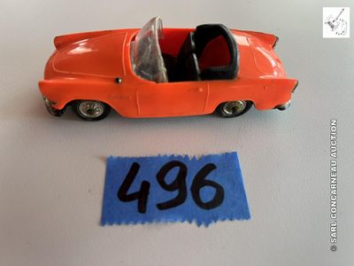 une petite voiture orange posée à côté d'une feuille de papier bleue