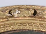 a close up of a gold mirror with a bird on it