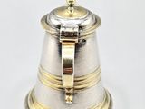 an antique silver and gold plated teapot on a white background