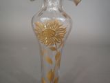 a glass vase with a gold flower on it