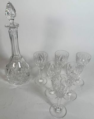 a lot of wine glasses and a decanter on the table