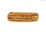 gros plan d'un bracelet en or sur fond blanc