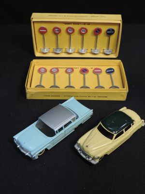 three toy cars in a yellow box on a black surface