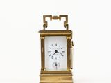 a small clock that is sitting on a white surface