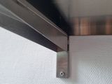 a close up of a metal shelf with a metal bar