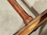 a close up of a wooden chair with a metal frame