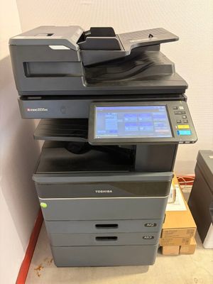 une imprimante posée sur une pile de cartons