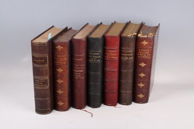 plusieurs vieux livres sont alignés sur une surface blanche