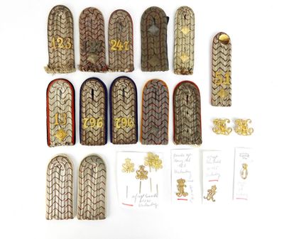Plusieurs types d'uniformes militaires sont disposés sur une surface blanche