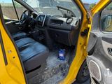 a yellow truck with its door open next to a black car