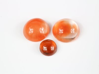 trois billes orange et blanches sur une surface blanche