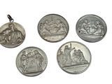 four silver coins are shown on a white surface