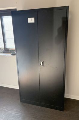 a black metal cabinet in a room with a window