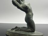 sculpture représentant une femme sur une planche de surf posée sur une surface réfléchissante