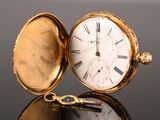 une montre de poche en or posée sur une table