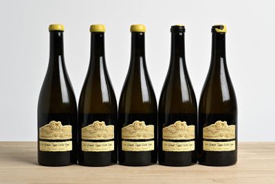 six bouteilles de vin sont alignées sur une table en bois
