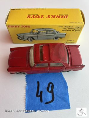 une petite voiture rouge posée sur un tissu bleu
