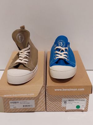 two pairs of blue and brown converses are on a cardboard box