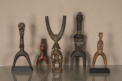 cinq figurines en bois posées sur une table en verre