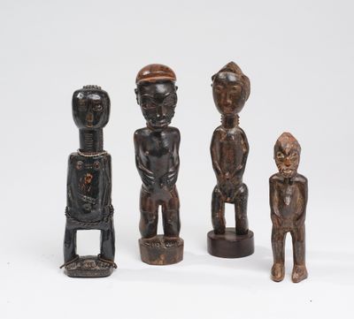 un ensemble de quatre figurines en bois sculptées, de formes et de tailles différentes