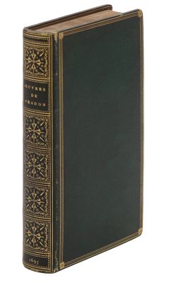 un vieux livre à la couverture noire et aux bordures dorées